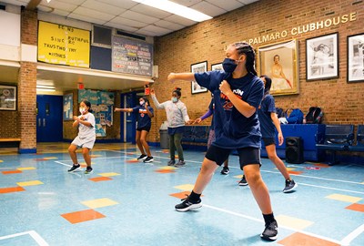 Rising New York Road Runners kids wearing masks and social distancing while exercising indoors