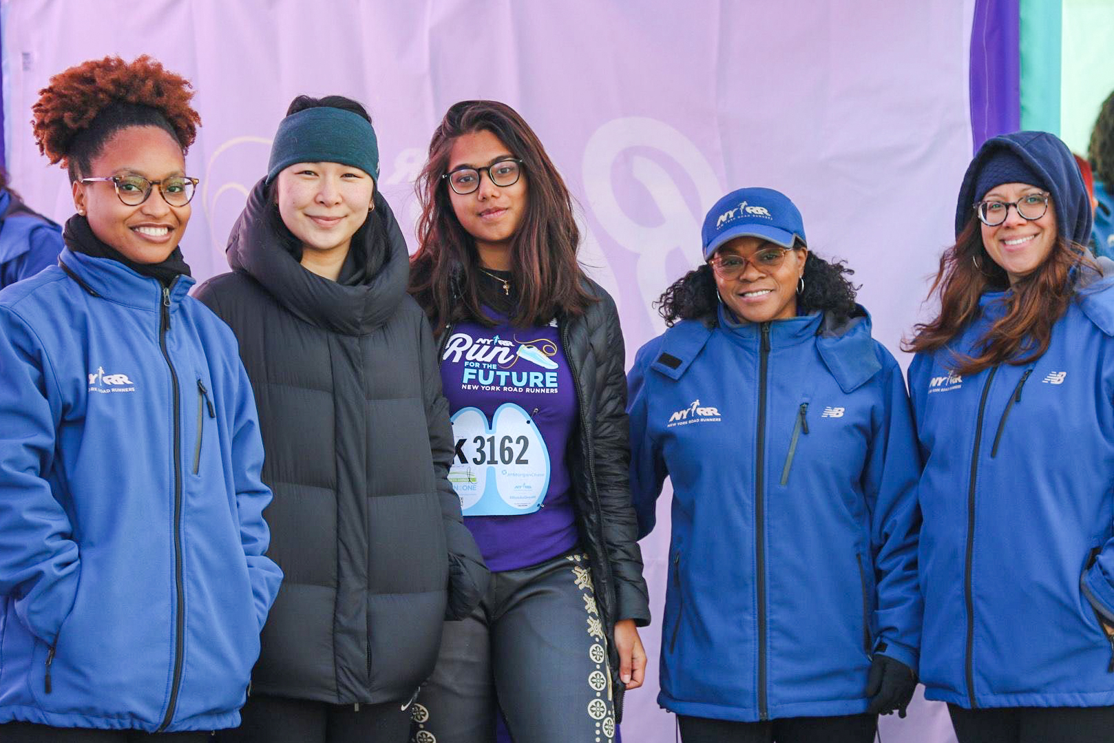 Two RFTF alumnae with NYRR staff inside tent at Run as One race