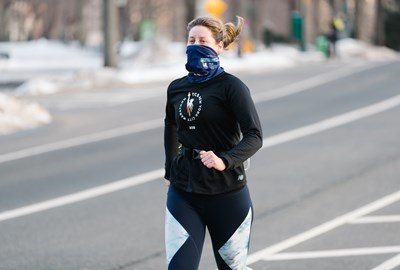 Woman runner wearing a buff at NYRR Group Training in Central Park in winter 2021